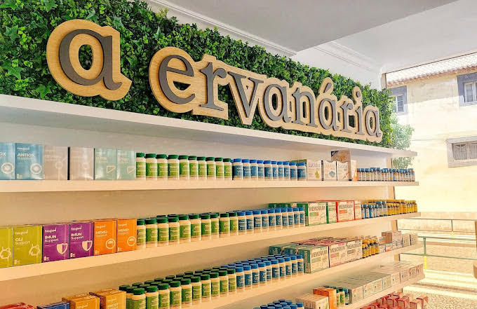 Interior da loja A Ervanária, com o nome completo da marca e produtos nas prateleiras